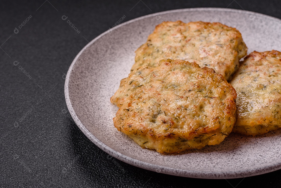 Deliciosas costeletas de frango picado frito com sal, especiarias e ervas sobre um fundo escuro de concreto
