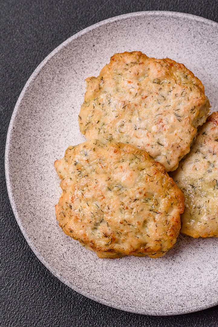 Deliciosas costeletas de frango picado frito com sal, especiarias e ervas sobre um fundo escuro de concreto
