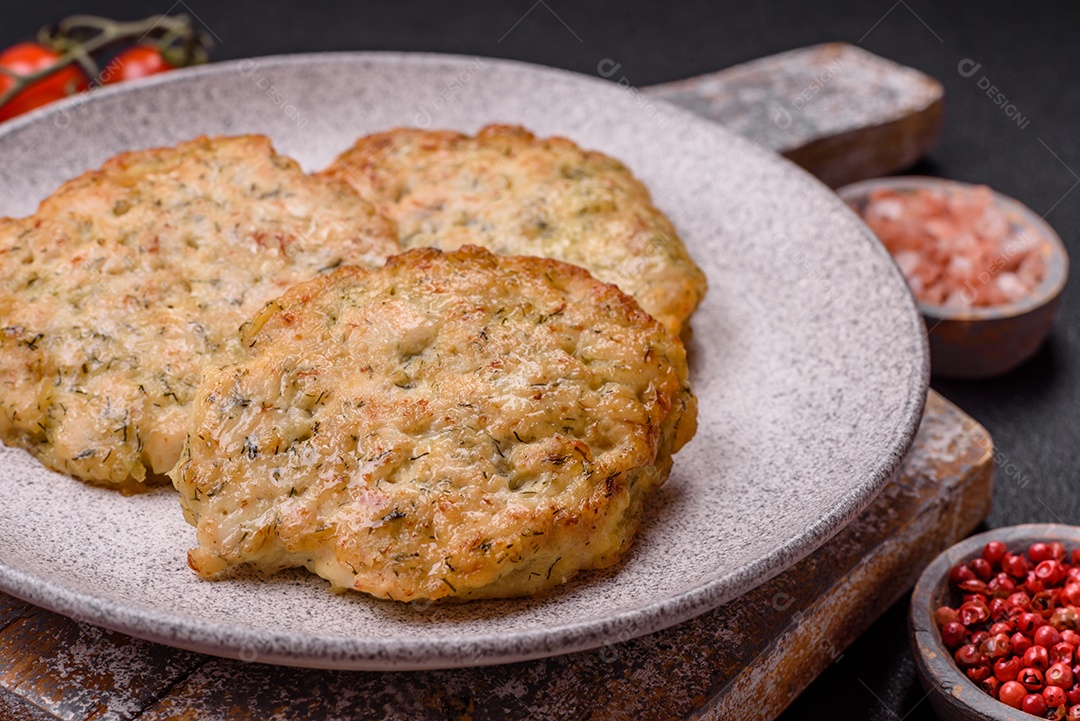 Deliciosas costeletas de frango picado frito com sal, especiarias e ervas sobre um fundo escuro de concreto