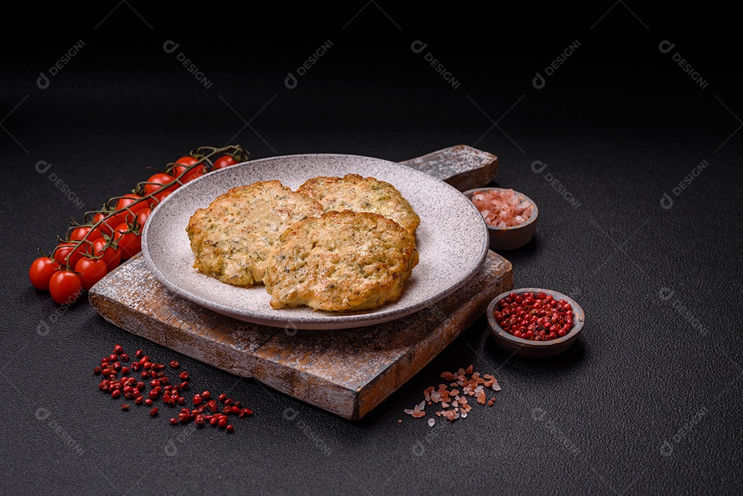 Deliciosas costeletas de frango picado frito com sal, especiarias e ervas sobre um fundo escuro de concreto