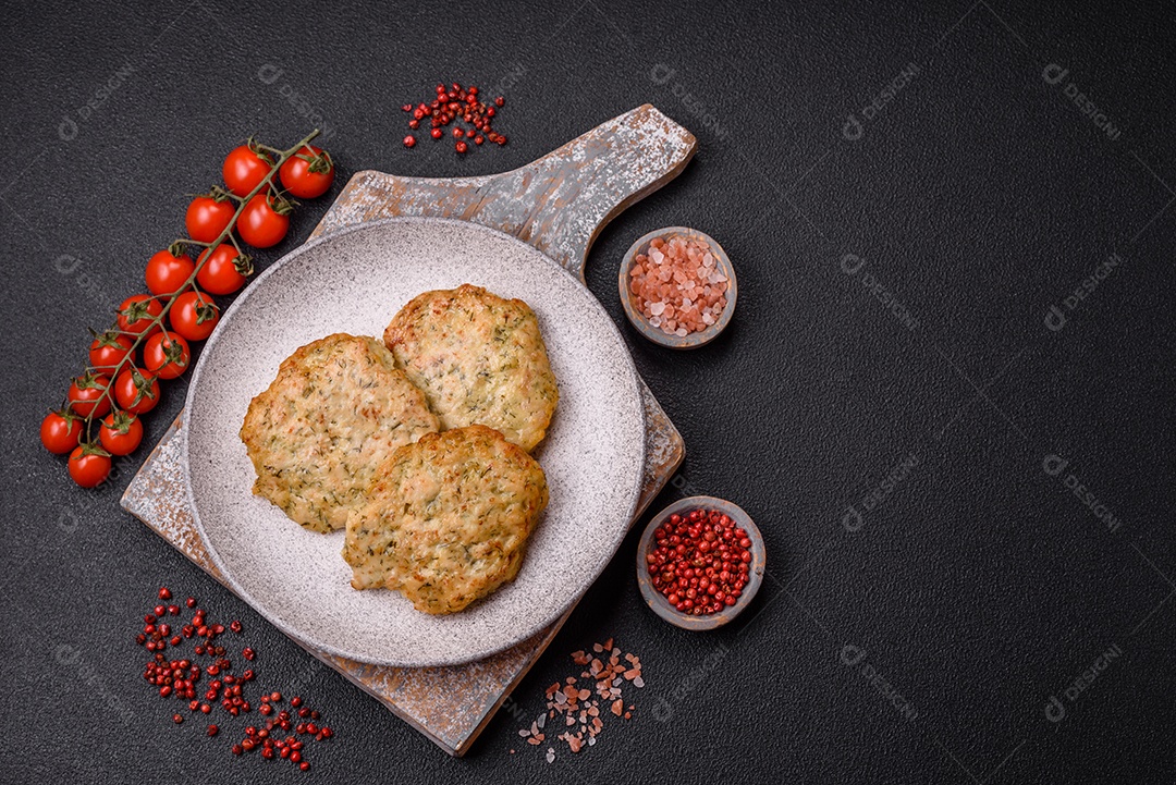 Deliciosas costeletas de frango picado frito com sal, especiarias e ervas sobre um fundo escuro de concreto