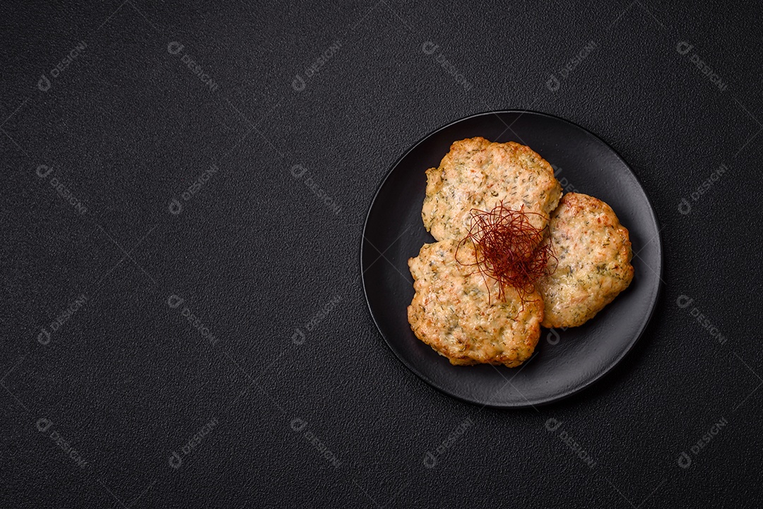 Deliciosas costeletas de frango picado frito com sal, especiarias e ervas sobre um fundo escuro de concreto
