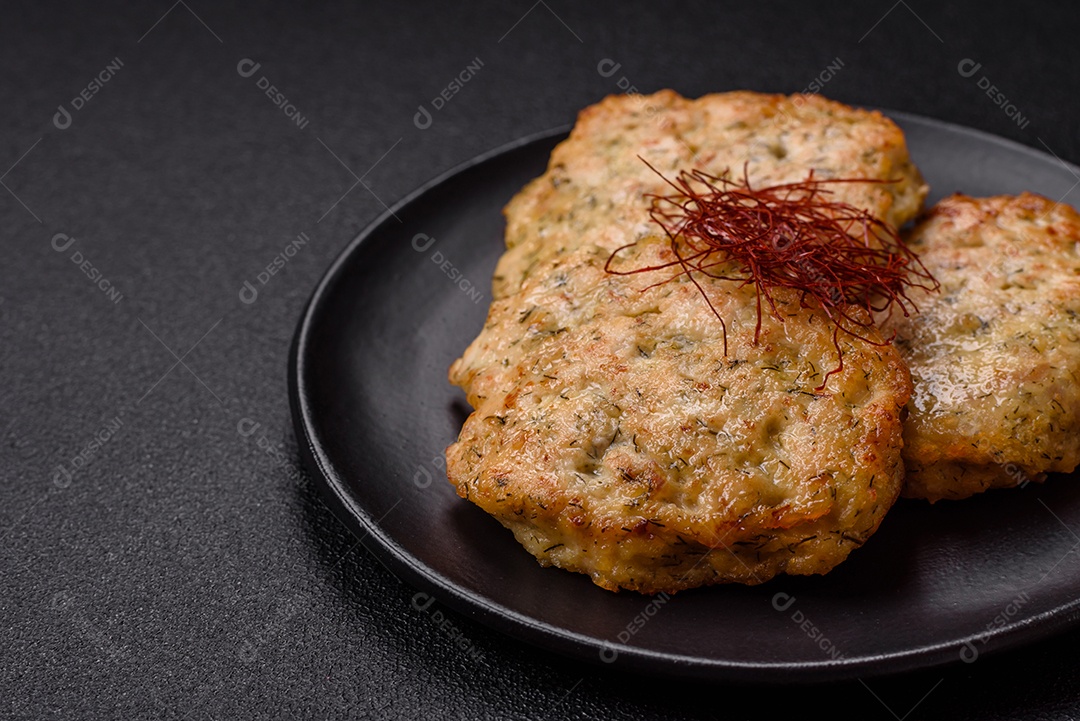 Deliciosas costeletas de frango picado frito com sal, especiarias e ervas sobre um fundo escuro de concreto