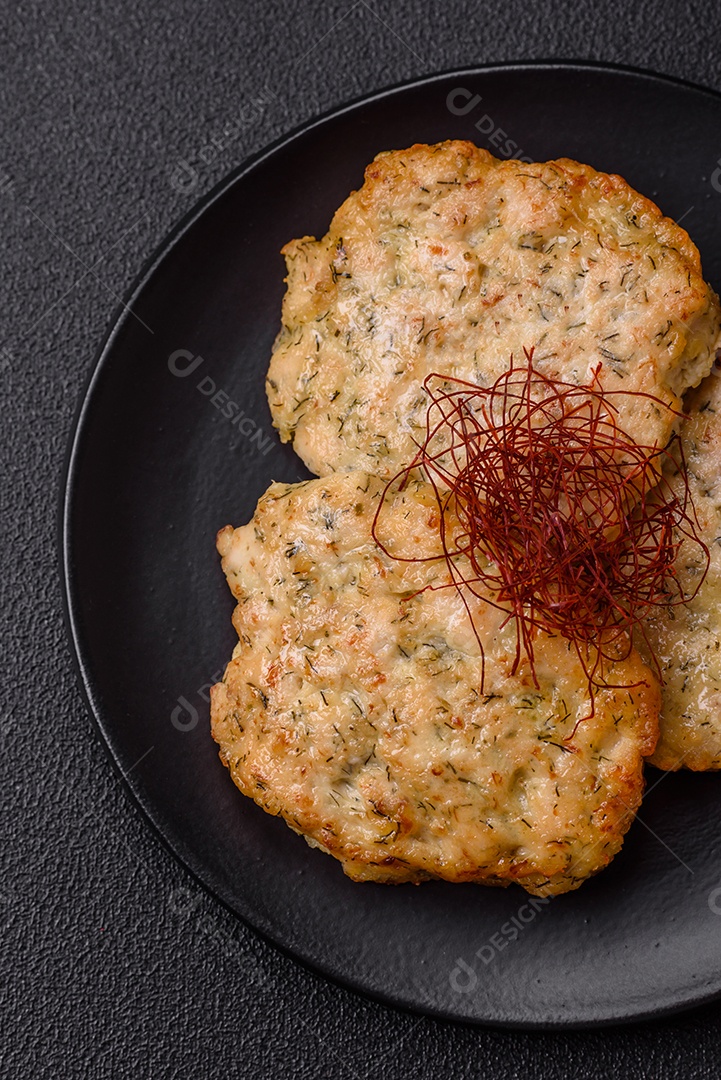 Deliciosas costeletas de frango picado frito com sal, especiarias e ervas sobre um fundo escuro de concreto