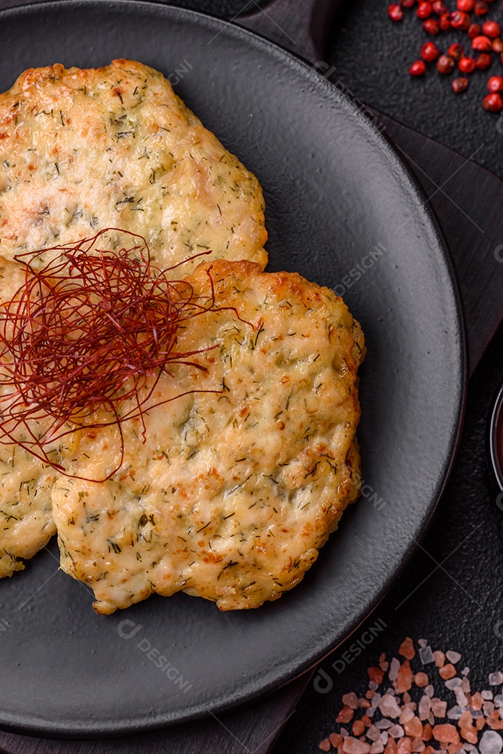 Deliciosas costeletas de frango picado frito com sal, especiarias e ervas sobre um fundo escuro de concreto