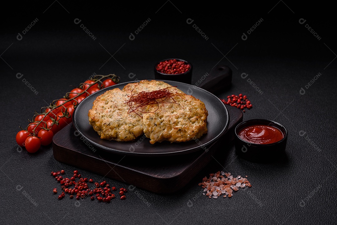 Deliciosas costeletas de frango picado frito com sal, especiarias e ervas sobre um fundo escuro de concreto