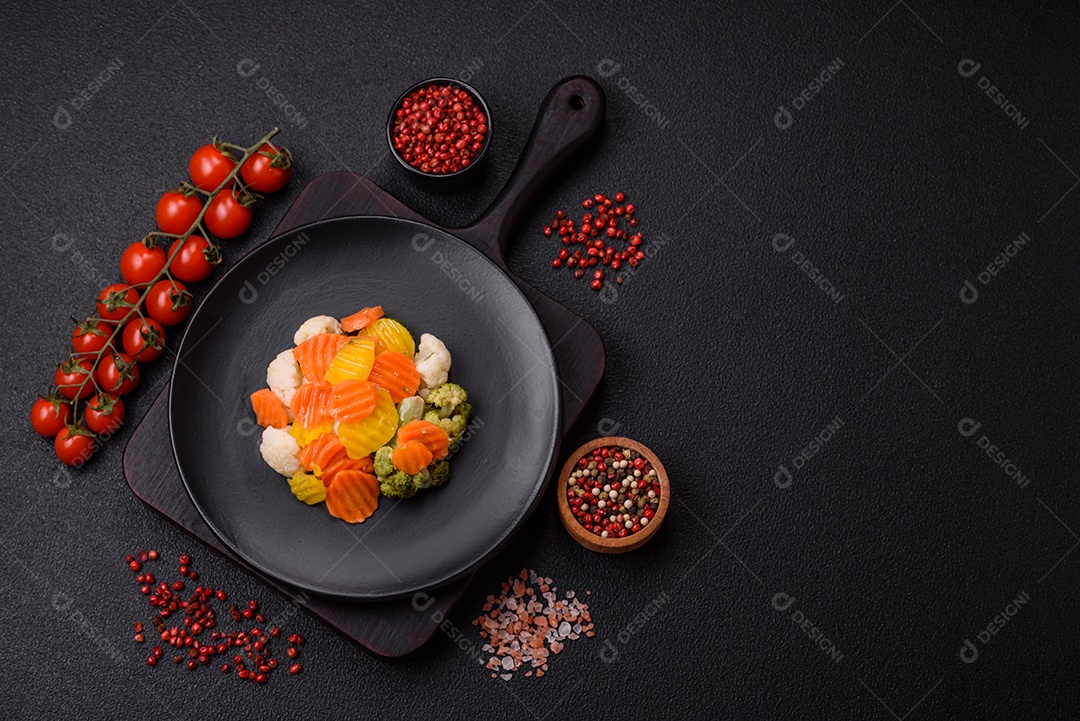 Deliciosos legumes frescos, brócolis, couve-flor, cenouras cozidas no vapor com sal, especiarias e ervas sobre fundo liso