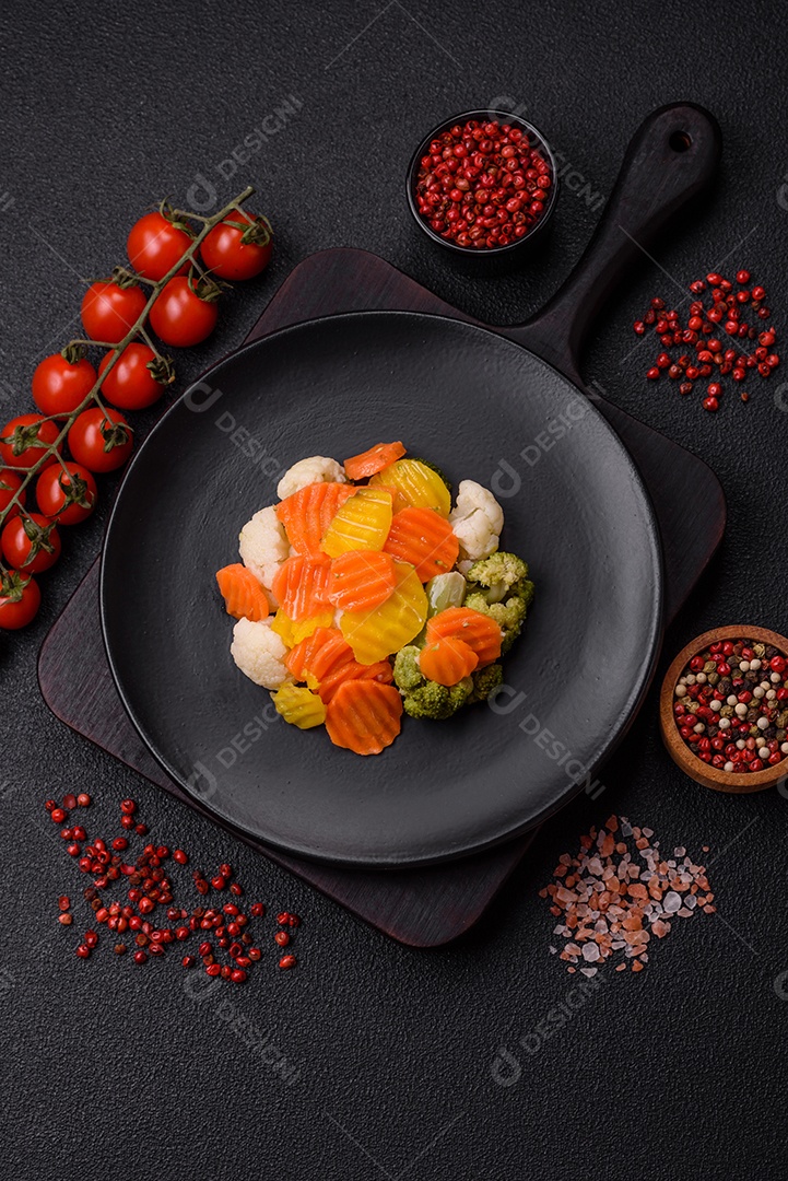 Deliciosos legumes frescos, brócolis, couve-flor, cenouras cozidas no vapor com sal, especiarias e ervas sobre fundo liso