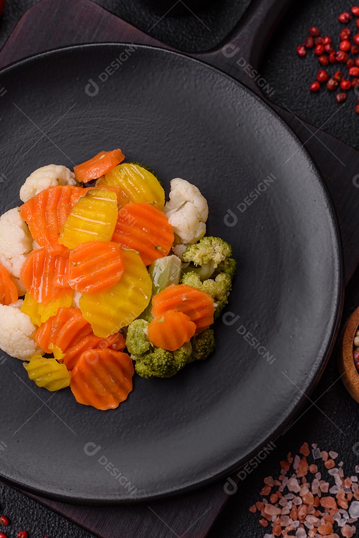 Deliciosos legumes frescos, brócolis, couve-flor, cenouras cozidas no vapor com sal, especiarias e ervas sobre fundo liso