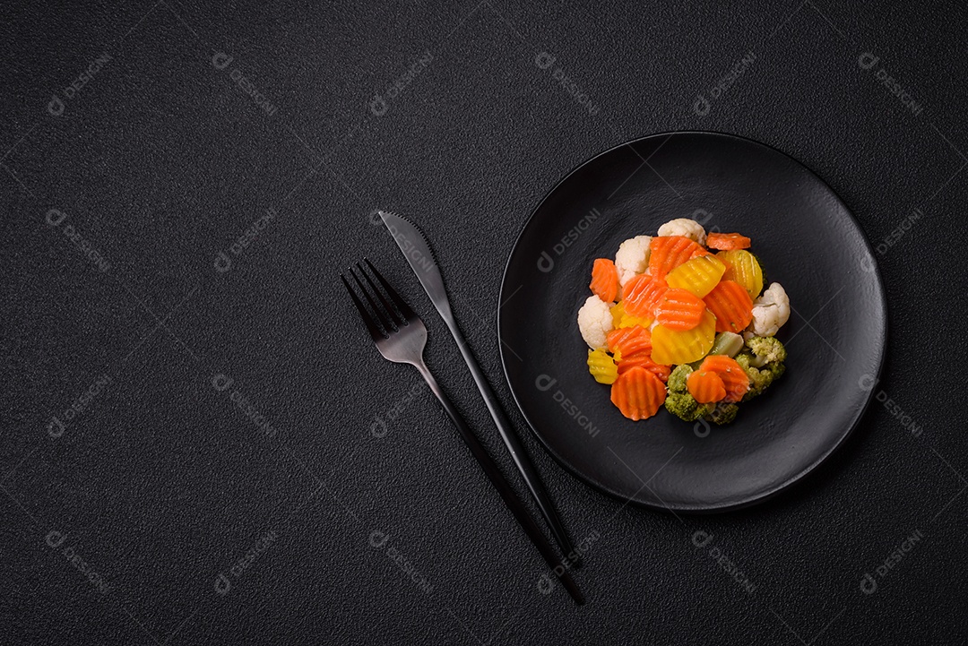 Deliciosos legumes frescos, brócolis, couve-flor, cenouras cozidas no vapor com sal, especiarias e ervas sobre fundo liso