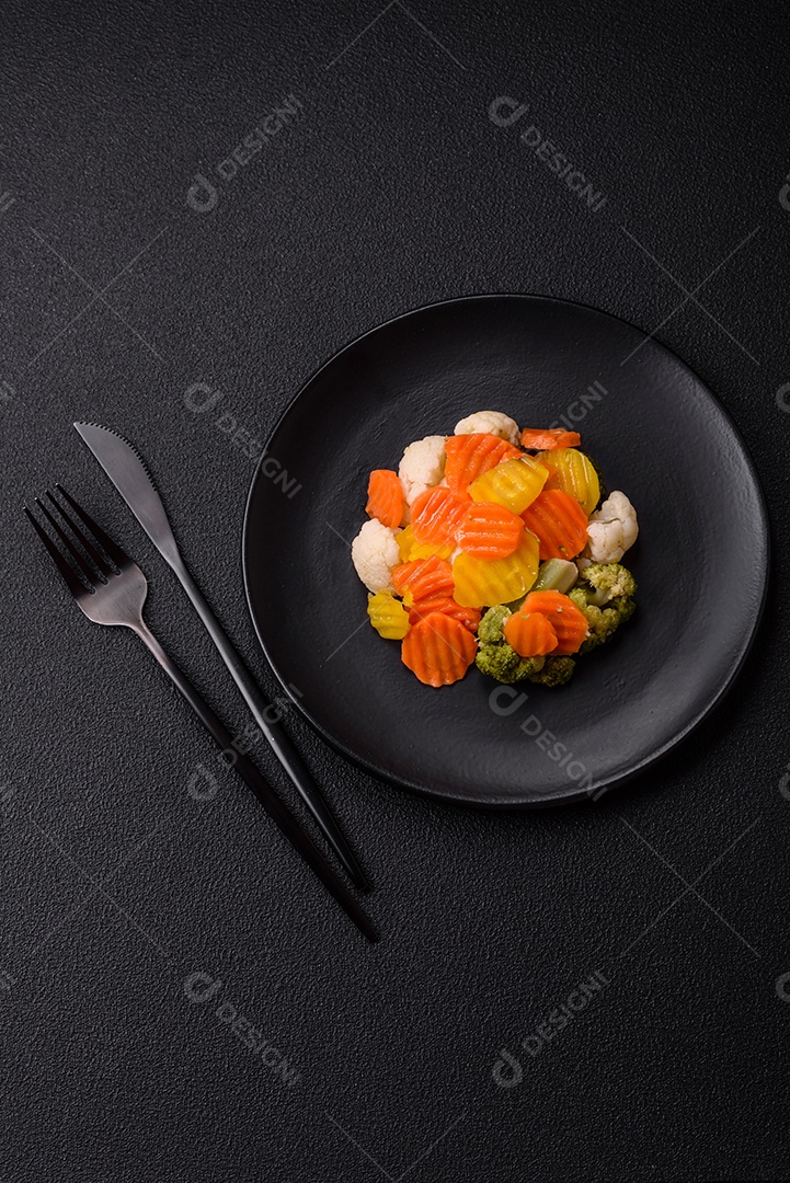 Deliciosos legumes frescos, brócolis, couve-flor, cenouras cozidas no vapor com sal, especiarias e ervas sobre fundo liso