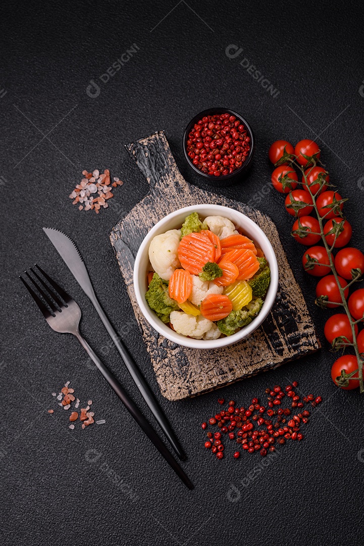 Deliciosos legumes frescos, brócolis, couve-flor, cenouras cozidas no vapor com sal, especiarias e ervas sobre fundo liso