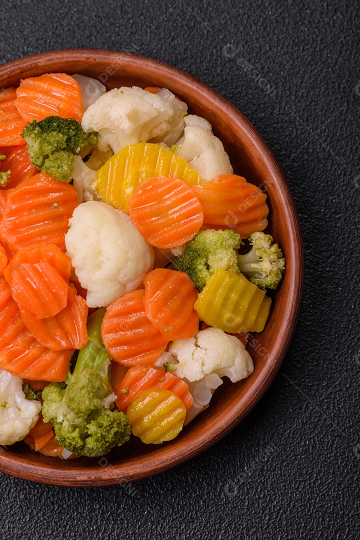 Deliciosos legumes frescos, brócolis, couve-flor, cenouras cozidas no vapor com sal, especiarias e ervas sobre fundo liso