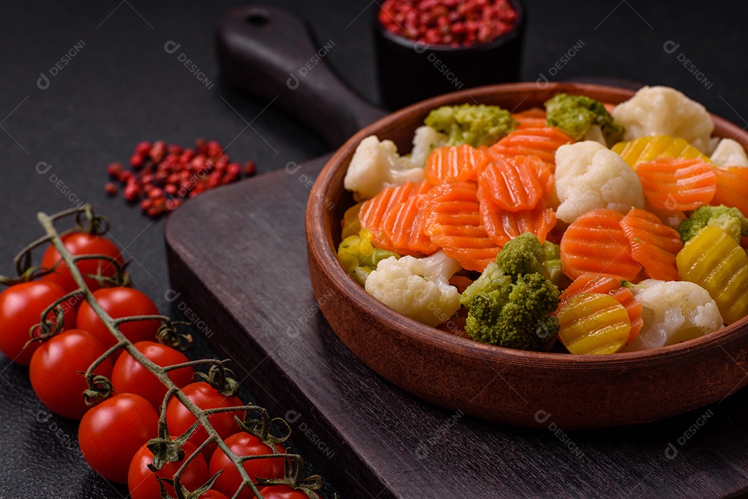 Deliciosos legumes frescos, brócolis, couve-flor, cenouras cozidas no vapor com sal, especiarias e ervas sobre fundo liso