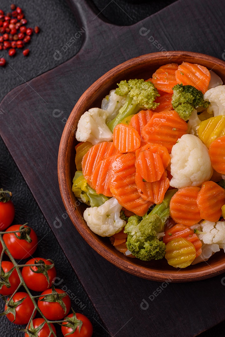 Deliciosos legumes frescos, brócolis, couve-flor, cenouras cozidas no vapor com sal, especiarias e ervas sobre fundo liso