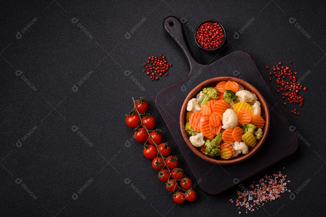 Deliciosos legumes frescos, brócolis, couve-flor, cenouras cozidas no vapor com sal, especiarias e ervas sobre fundo liso