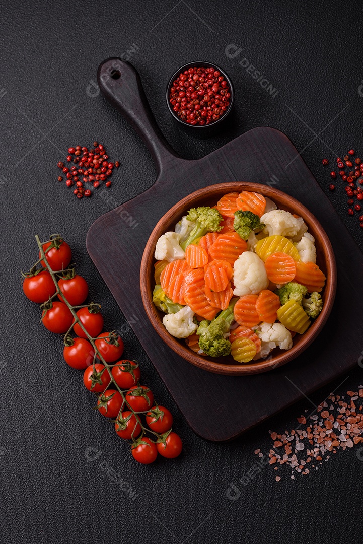 Deliciosos legumes frescos, brócolis, couve-flor, cenouras cozidas no vapor com sal, especiarias e ervas sobre fundo liso