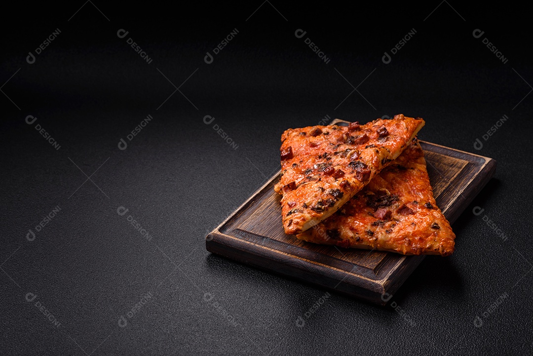 Fatias de deliciosa pizza de rua com salsicha, cogumelos, tomate e queijo com sal e especiarias sobre um fundo escuro de concreto