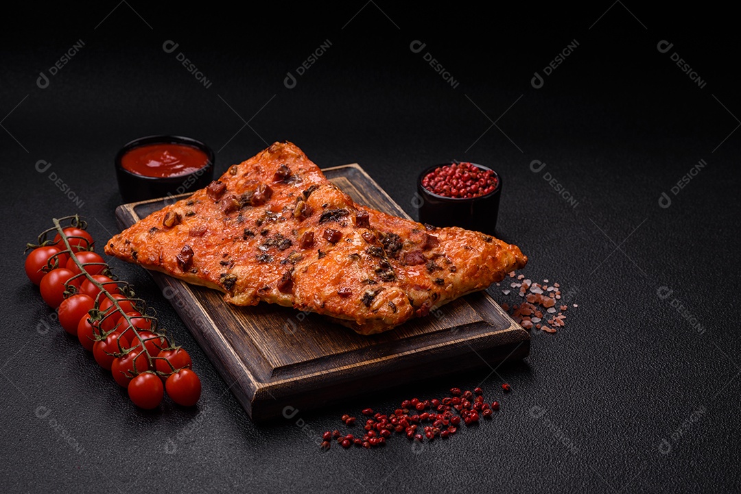 Fatias de deliciosa pizza de rua com salsicha, cogumelos, tomate e queijo com sal e especiarias sobre um fundo escuro de concreto
