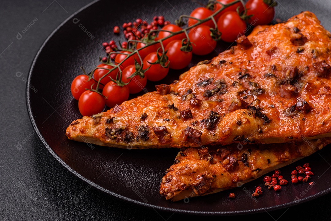 Fatias de deliciosa pizza de rua com salsicha, cogumelos, tomate e queijo com sal e especiarias sobre um fundo escuro de concreto