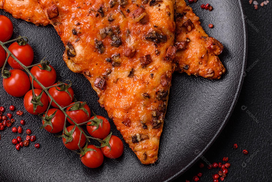 Fatias de deliciosa pizza de rua com salsicha, cogumelos, tomate e queijo com sal e especiarias sobre um fundo escuro de concreto