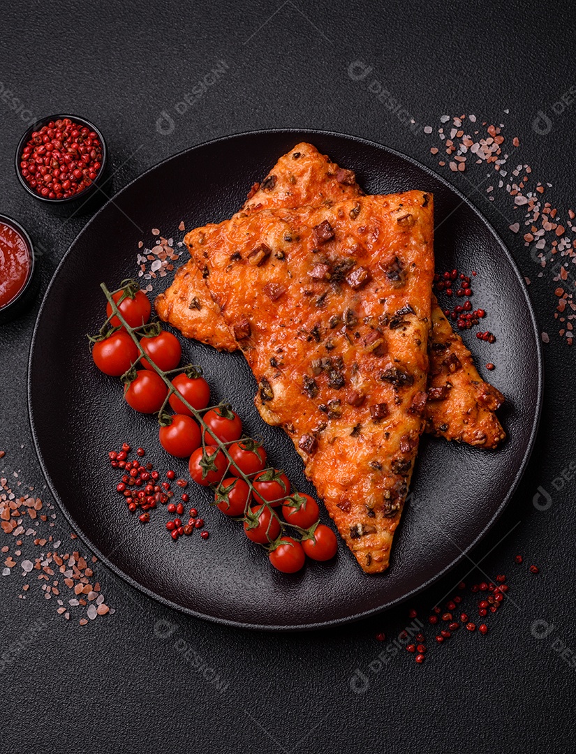 Fatias de deliciosa pizza de rua com salsicha, cogumelos, tomate e queijo com sal e especiarias sobre um fundo escuro de concreto