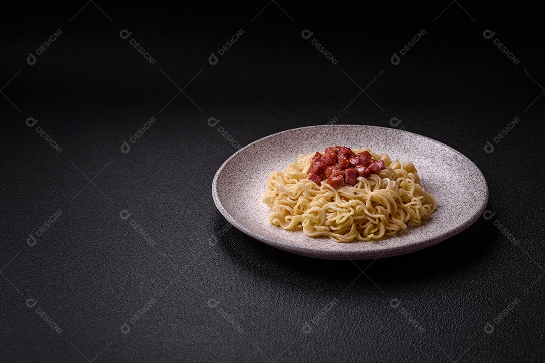 Delicioso macarrão de arroz asiático ou udon com legumes, especiarias e ervas sobre um fundo escuro de concreto
