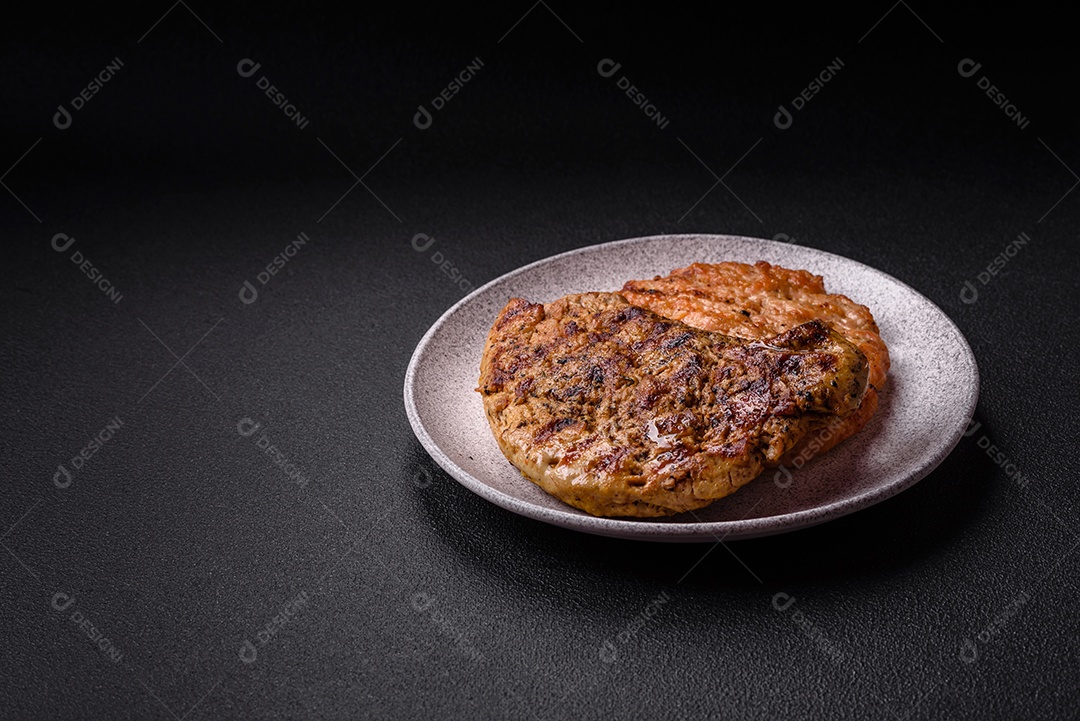 Delicioso peru suculento ou bife de frango com sal, especiarias e ervas sobre um fundo escuro de concreto