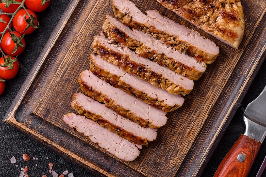 Delicioso peru suculento ou bife de frango com sal, especiarias e ervas sobre um fundo escuro de concreto