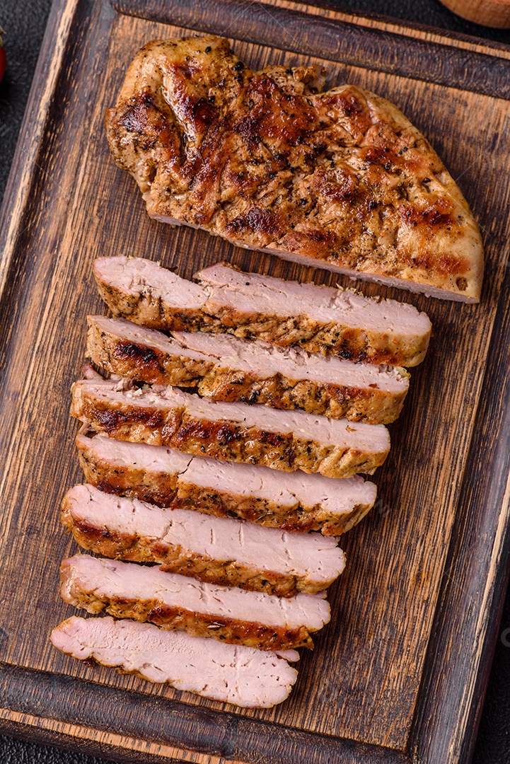 Delicioso peru suculento ou bife de frango com sal, especiarias e ervas sobre um fundo escuro de concreto