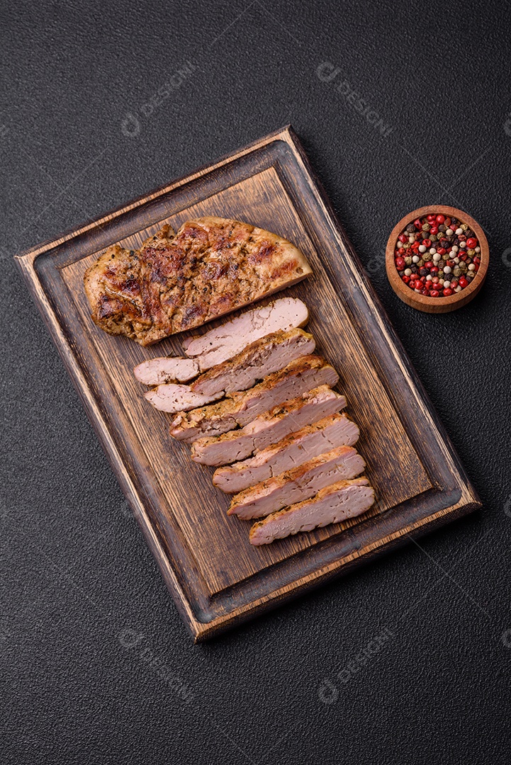 Delicioso peru suculento ou bife de frango com sal, especiarias e ervas sobre um fundo escuro de concreto