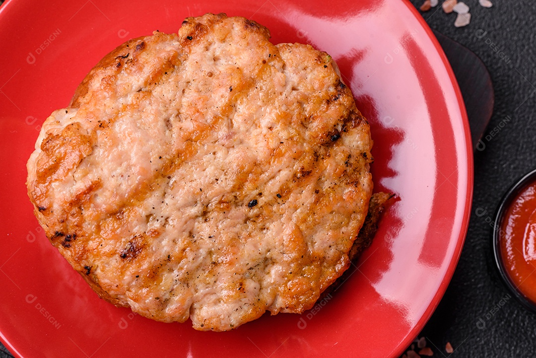 Delicioso peru suculento ou bife de frango com sal, especiarias e ervas sobre um fundo escuro de concreto