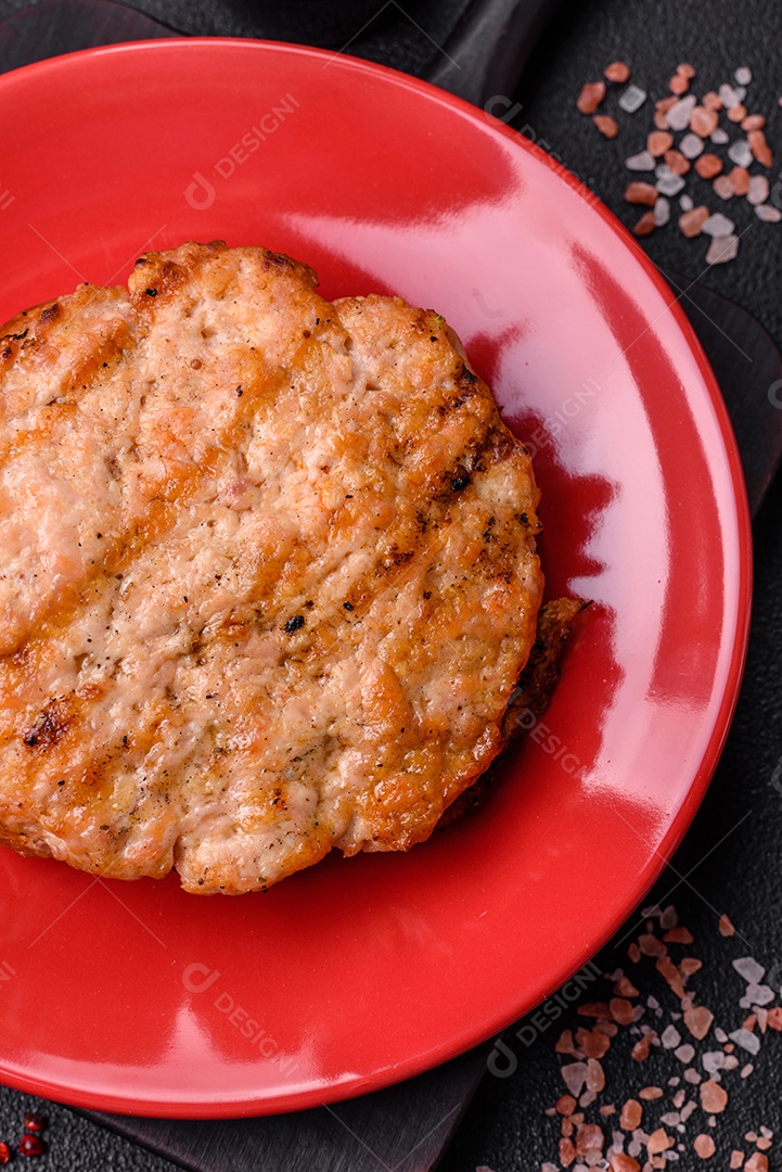 Delicioso peru suculento ou bife de frango com sal, especiarias e ervas sobre um fundo escuro de concreto