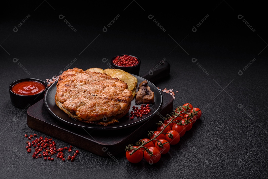 Delicioso peru suculento ou bife de frango com sal, especiarias e ervas sobre um fundo escuro de concreto