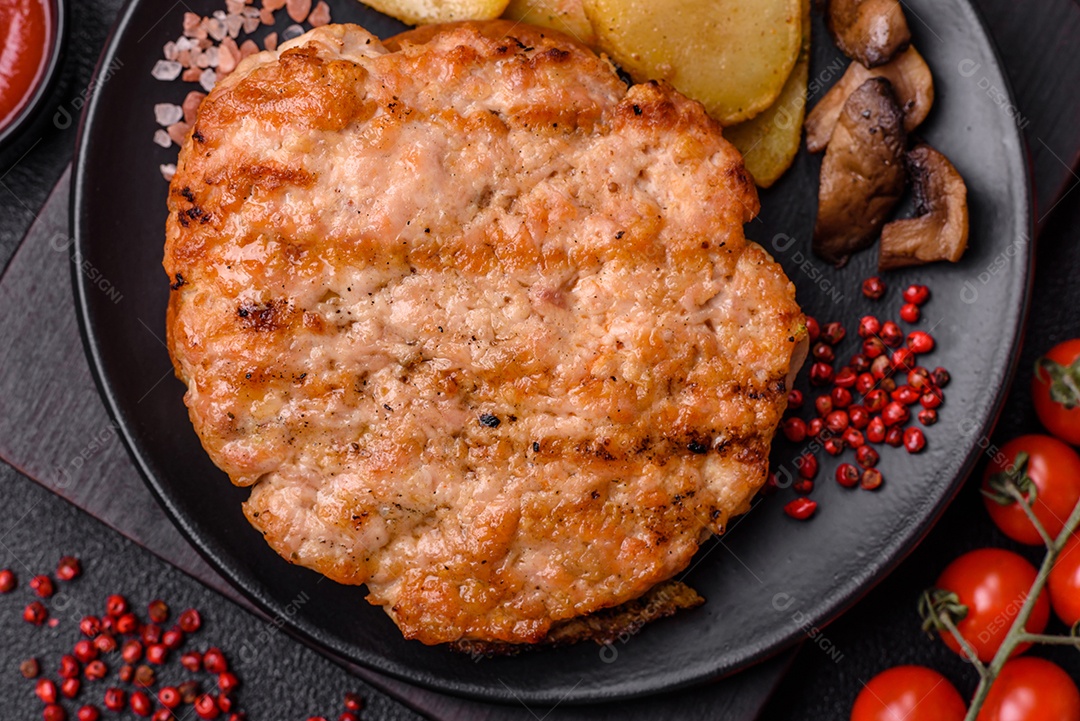 Delicioso peru suculento ou bife de frango com sal, especiarias e ervas sobre um fundo escuro de concreto