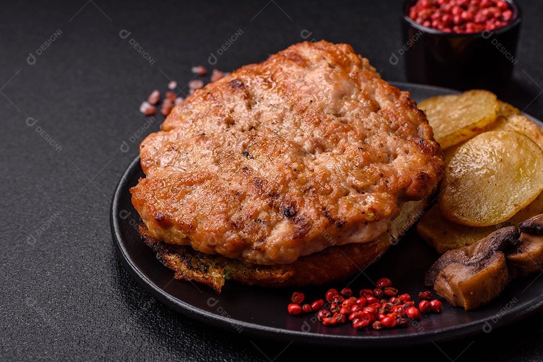 Delicioso peru suculento ou bife de frango com sal, especiarias e ervas sobre um fundo escuro de concreto