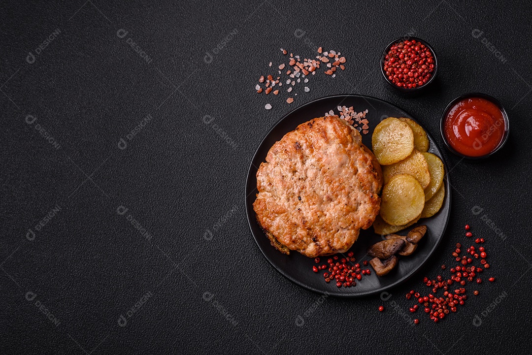 Delicioso peru suculento ou bife de frango com sal, especiarias e ervas sobre um fundo escuro de concreto