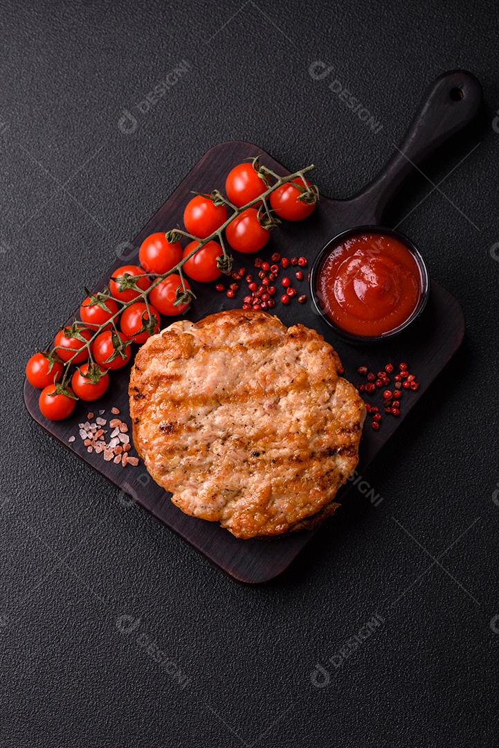 Delicioso peru suculento ou bife de frango com sal, especiarias e ervas sobre um fundo escuro de concreto