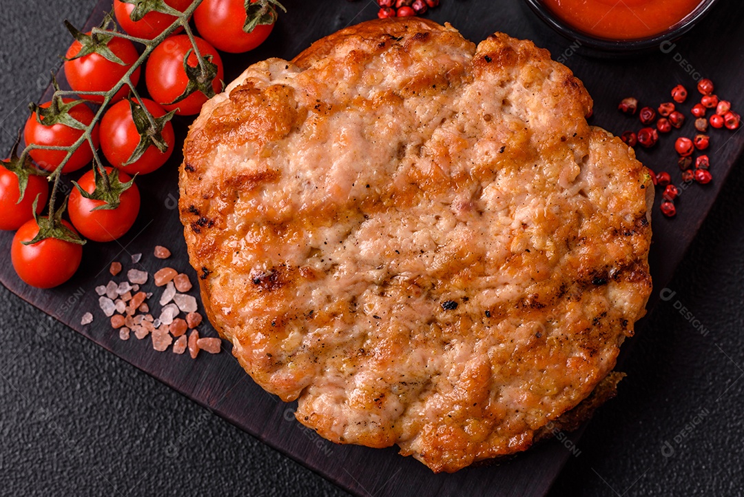 Delicioso peru suculento ou bife de frango com sal, especiarias e ervas sobre um fundo escuro de concreto