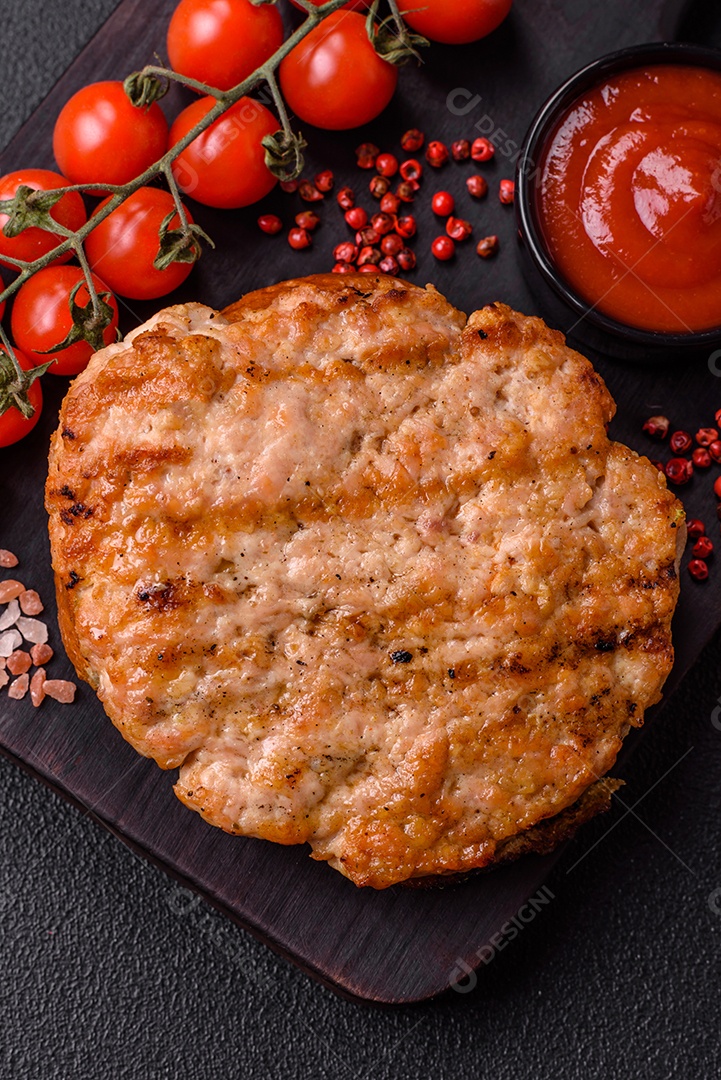 Delicioso peru suculento ou bife de frango com sal, especiarias e ervas sobre um fundo escuro de concreto