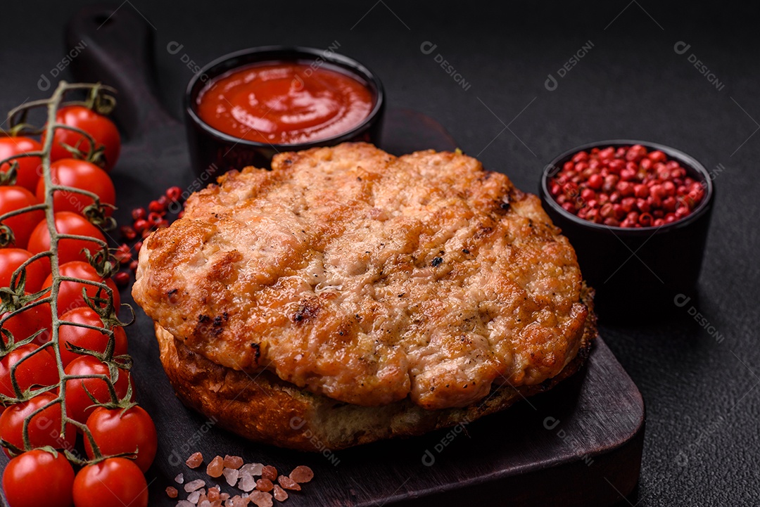 Delicioso peru suculento ou bife de frango com sal, especiarias e ervas sobre um fundo escuro de concreto