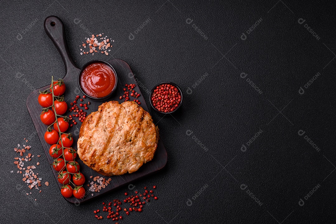 Delicioso peru suculento ou bife de frango com sal, especiarias e ervas sobre um fundo escuro de concreto