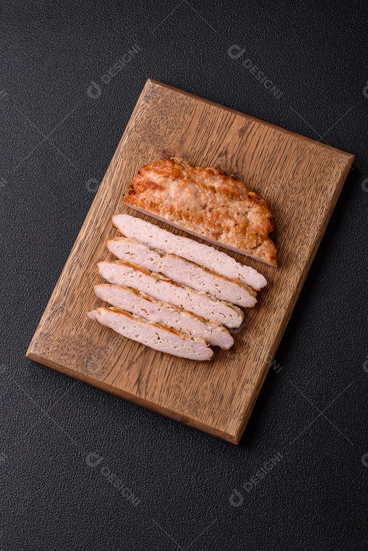 Delicioso peru suculento ou bife de frango com sal, especiarias e ervas sobre um fundo escuro de concreto