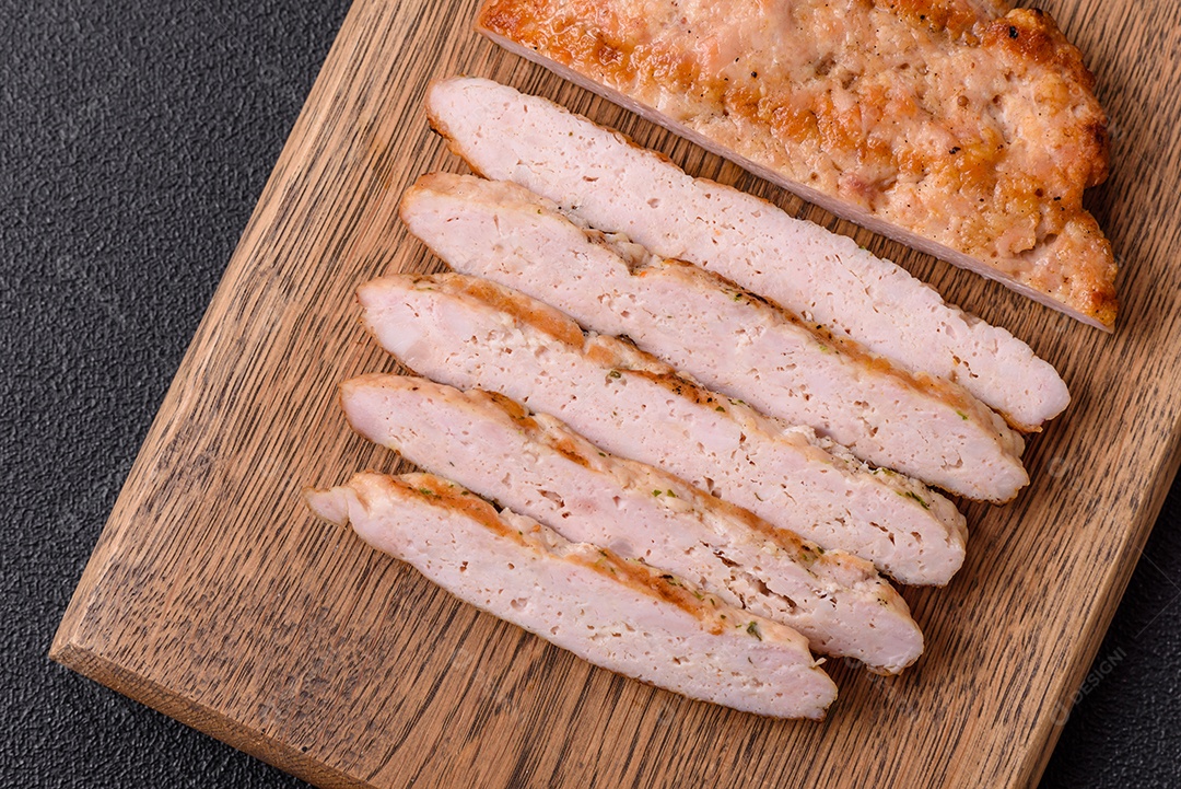 Delicioso peru suculento ou bife de frango com sal, especiarias e ervas sobre um fundo escuro de concreto