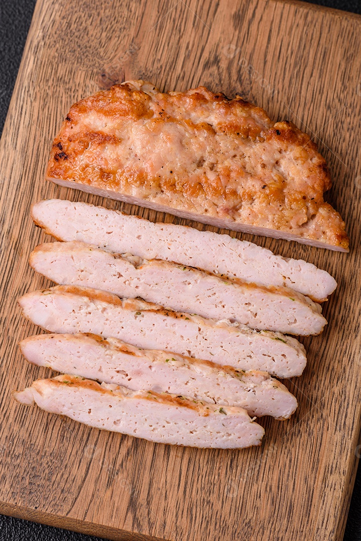 Delicioso peru suculento ou bife de frango com sal, especiarias e ervas sobre um fundo escuro de concreto