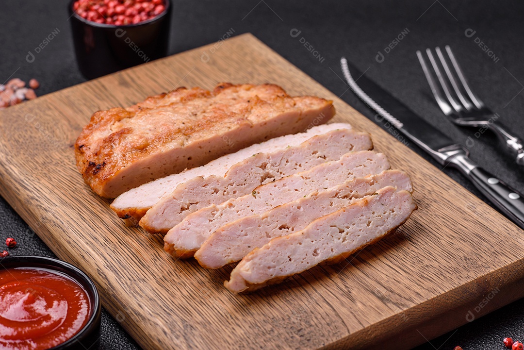 Delicioso peru suculento ou bife de frango com sal, especiarias e ervas sobre um fundo escuro de concreto