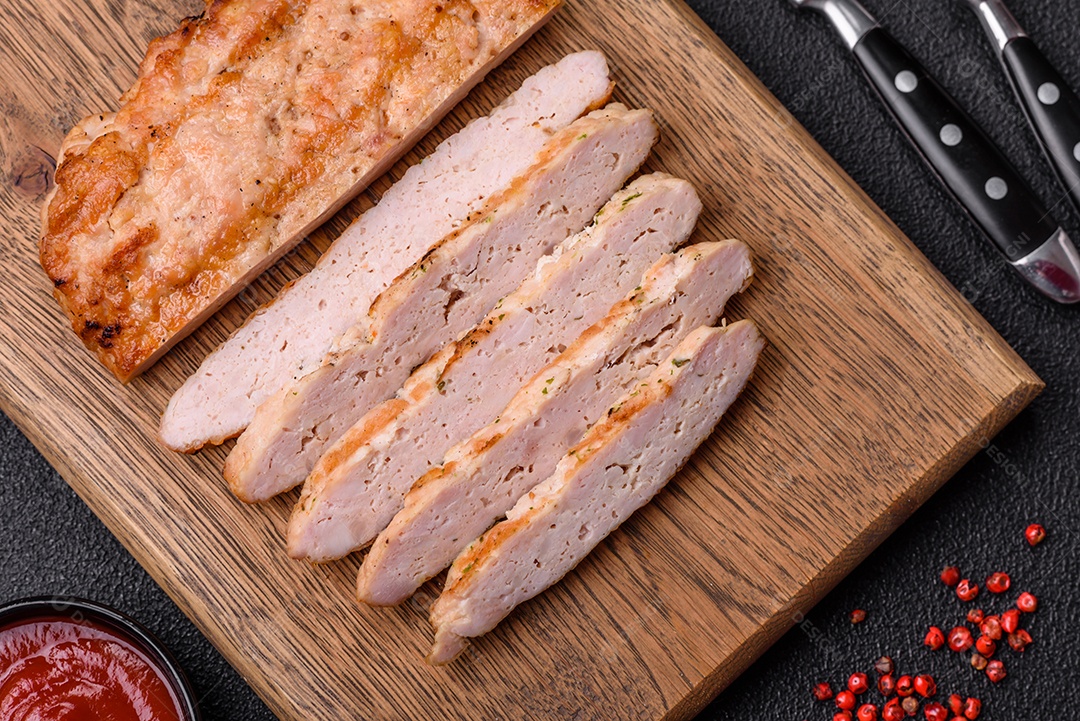 Delicioso peru suculento ou bife de frango com sal, especiarias e ervas sobre um fundo escuro de concreto