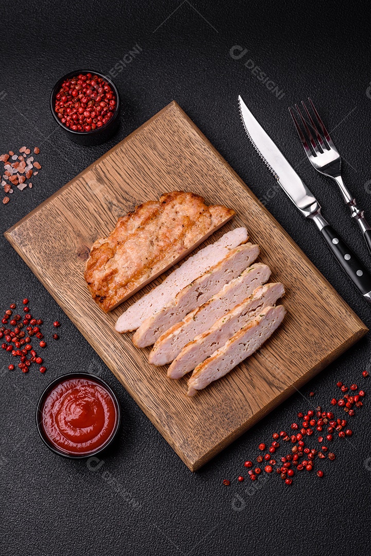 Delicioso peru suculento ou bife de frango com sal, especiarias e ervas sobre um fundo escuro de concreto