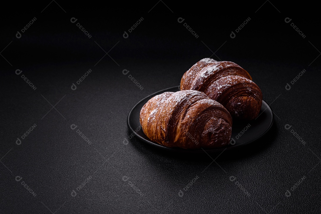 Delicioso croissant crocante doce fresco com chocolate em fundo escuro de concreto