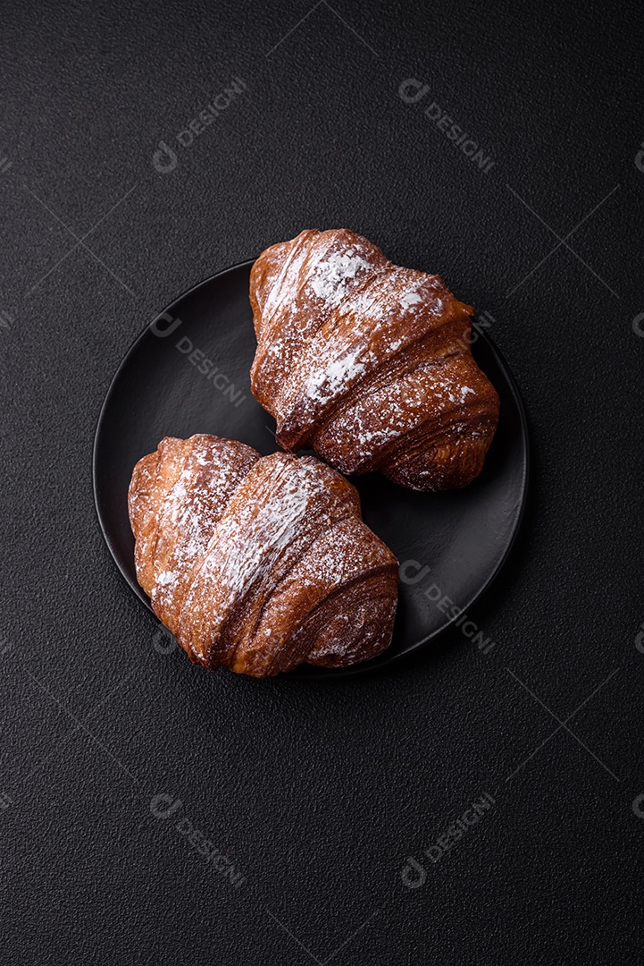 Delicioso croissant crocante doce fresco com chocolate em fundo escuro de concreto